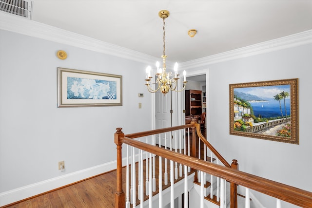 hall with wood-type flooring, a notable chandelier, and crown molding