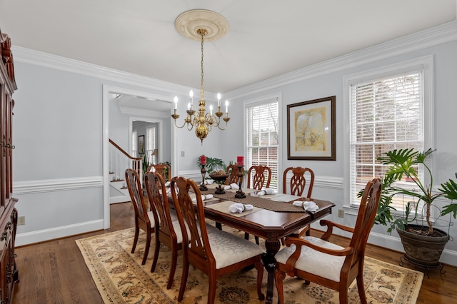 dining space featuring ornamental molding, dark hardwood / wood-style flooring, and a notable chandelier