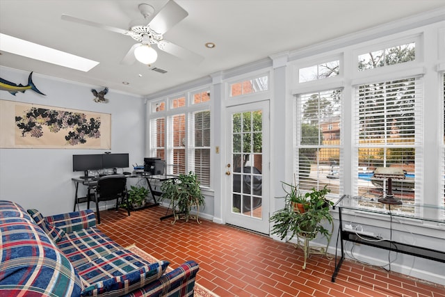 sunroom featuring ceiling fan and a skylight