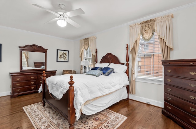 bedroom featuring dark wood-type flooring, ornamental molding, and ceiling fan