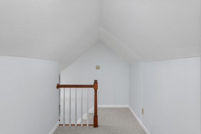 bonus room with vaulted ceiling and carpet flooring