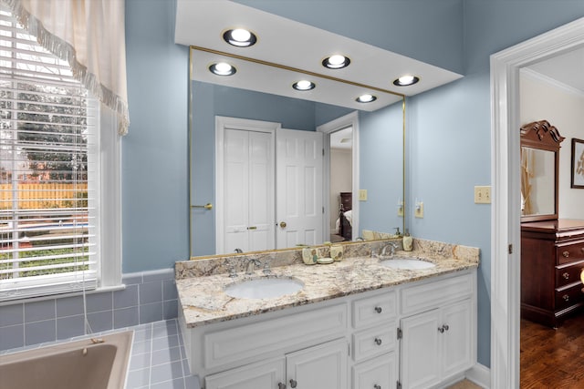 bathroom with vanity, hardwood / wood-style floors, and a bathtub