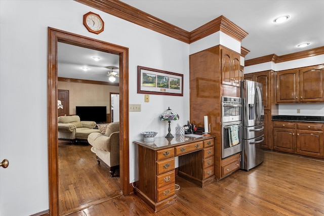 kitchen with crown molding, dark wood-type flooring, stainless steel appliances, and ceiling fan