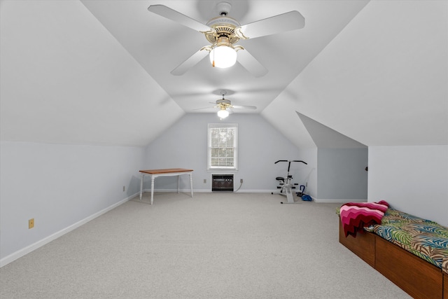 carpeted bedroom with vaulted ceiling, heating unit, and ceiling fan