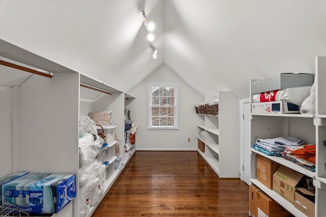 walk in closet featuring dark wood-type flooring and vaulted ceiling