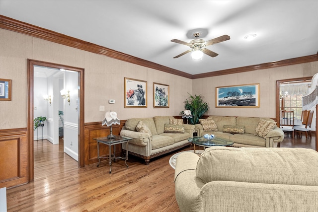 living room with crown molding, ceiling fan, and light wood-type flooring