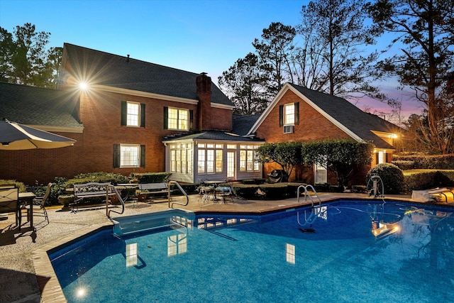 pool at dusk featuring a patio area