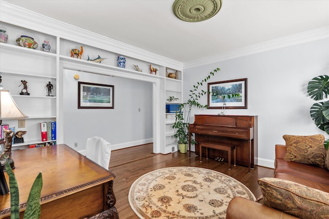 office area with built in shelves, ornamental molding, and dark hardwood / wood-style flooring