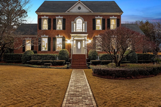 colonial-style house featuring a lawn