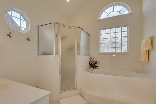 bathroom with vaulted ceiling, a shower stall, and a healthy amount of sunlight