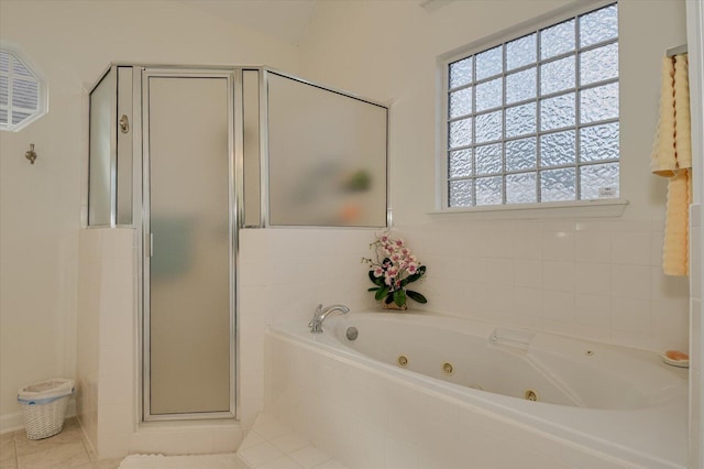 bathroom with a jetted tub, a stall shower, vaulted ceiling, and tile patterned floors