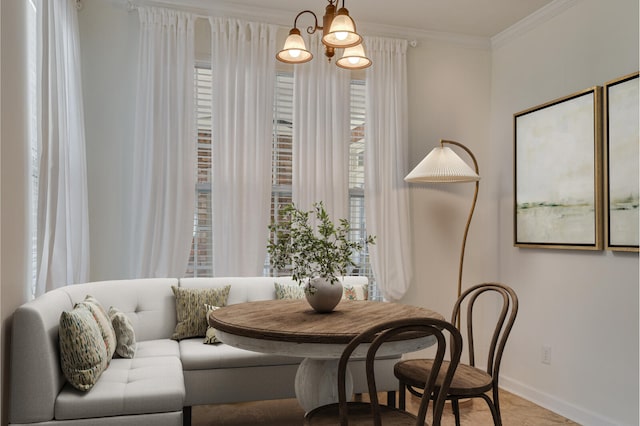 dining space featuring baseboards, ornamental molding, and a chandelier