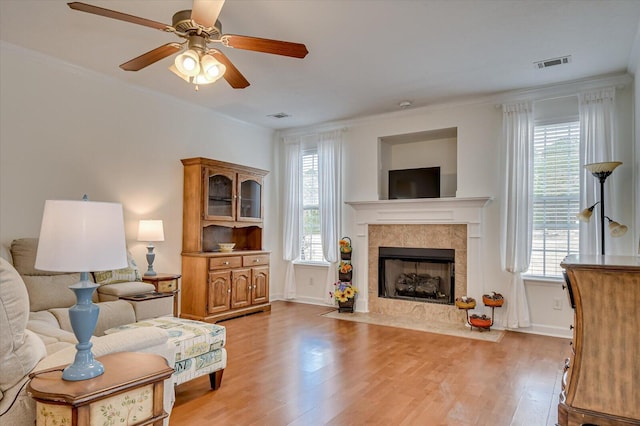 living area featuring ornamental molding, wood finished floors, and visible vents