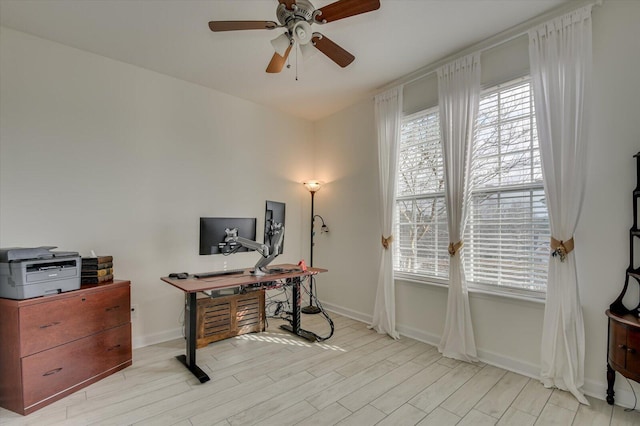 office space with a ceiling fan, light wood-style flooring, and baseboards