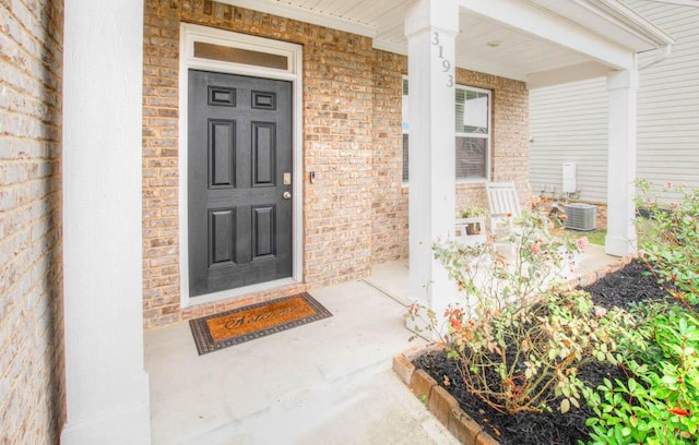 doorway to property with a porch and central AC unit