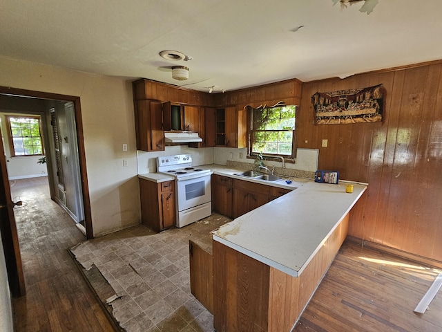 109 E E Walker St, Augusta, GA 30901 - kitchen with white range with electric cooktop, under cabinet range hood, a peninsula, light countertops, and wood finished floors