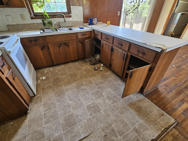 109 E E Walker St, Augusta, GA 30901 - kitchen with range, a peninsula, light countertops, light stone finish flooring, and brown cabinetry
