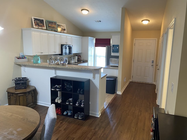 1908 Aspen Green Way, Augusta, GA 30909 - kitchen featuring white cabinets, dark wood-style flooring, a peninsula, vaulted ceiling, and a kitchen bar