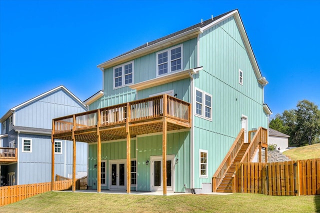 back of house featuring a lawn, a patio area, a deck, and french doors