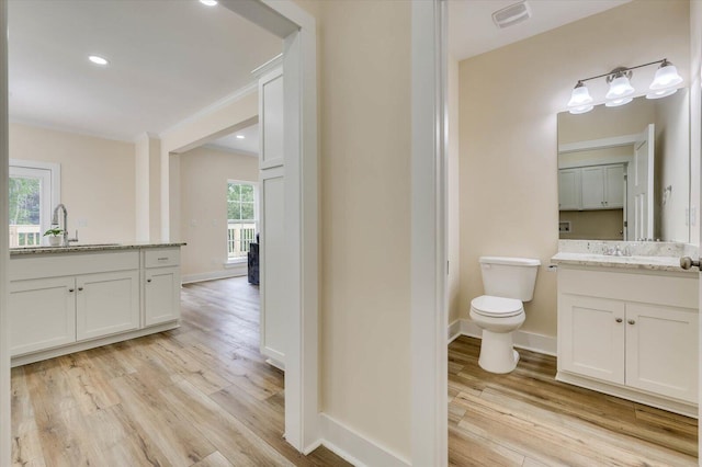 bathroom with crown molding, toilet, vanity, and hardwood / wood-style flooring