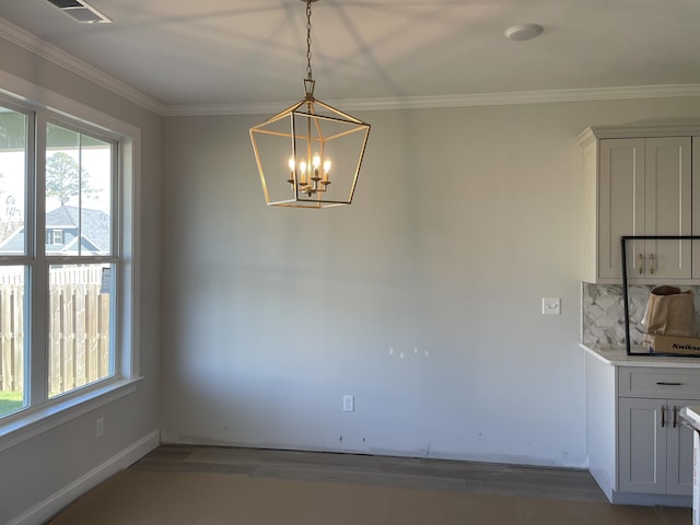 unfurnished dining area featuring visible vents, baseboards, dark wood-style floors, ornamental molding, and a notable chandelier