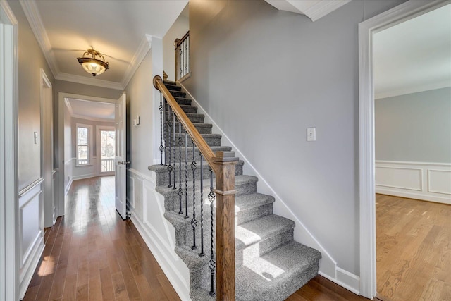 staircase featuring hardwood / wood-style flooring and ornamental molding