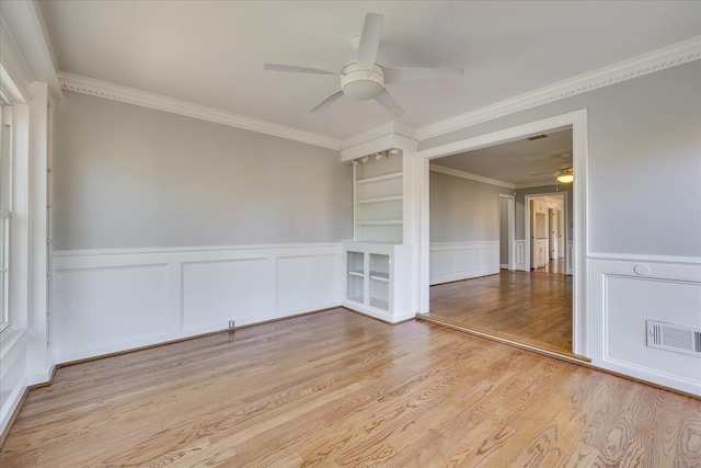 spare room featuring crown molding, ceiling fan, and light hardwood / wood-style floors