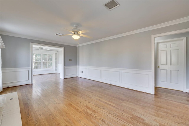 unfurnished room with crown molding, light hardwood / wood-style floors, and ceiling fan