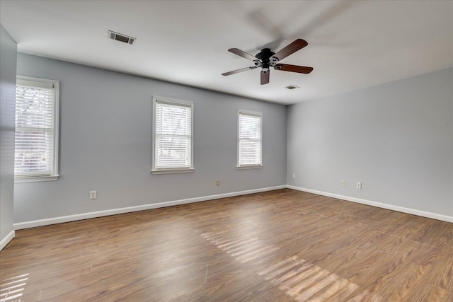 spare room with ceiling fan, plenty of natural light, and light wood-type flooring