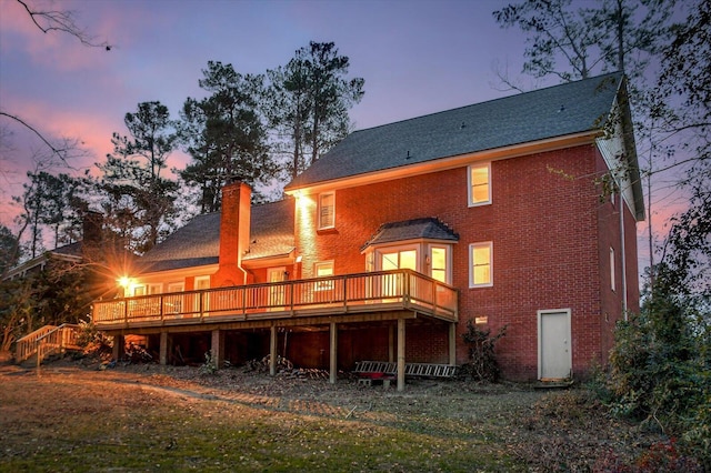 back house at dusk with a deck