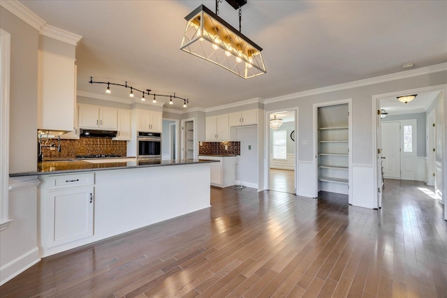 kitchen featuring a healthy amount of sunlight, dark hardwood / wood-style floors, hanging light fixtures, and white cabinets