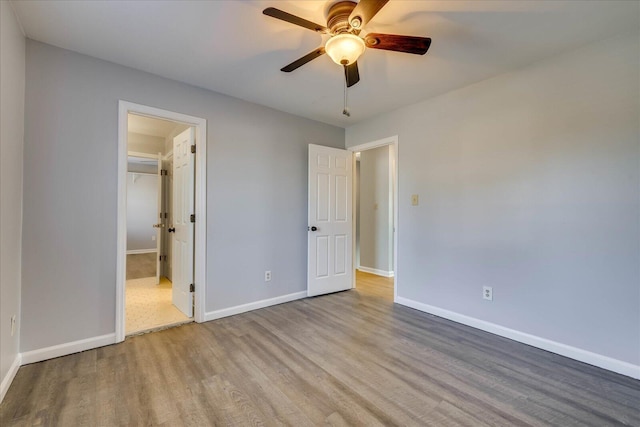 unfurnished bedroom with ensuite bath, light hardwood / wood-style flooring, and ceiling fan