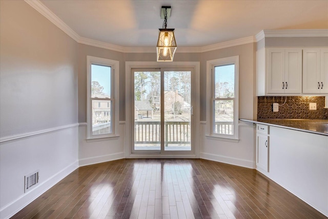 unfurnished dining area featuring crown molding and dark hardwood / wood-style floors