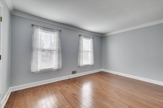 spare room with hardwood / wood-style floors and crown molding