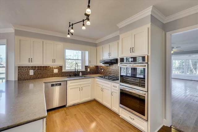 kitchen featuring sink, stainless steel appliances, light hardwood / wood-style floors, decorative backsplash, and white cabinets