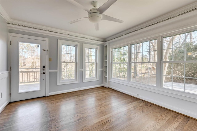 unfurnished sunroom featuring ceiling fan