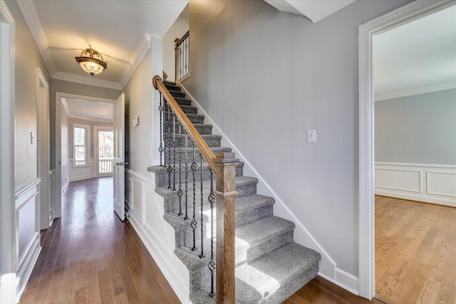 staircase with hardwood / wood-style flooring and ornamental molding