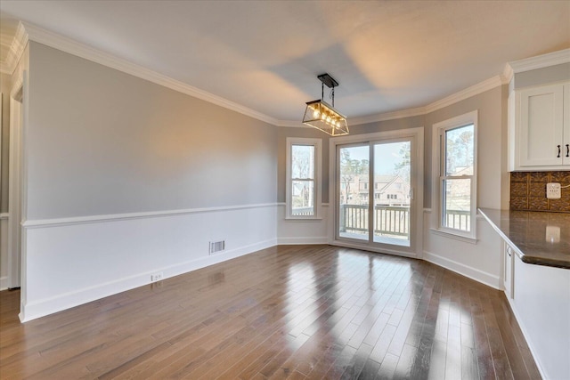 unfurnished dining area featuring crown molding and dark hardwood / wood-style floors