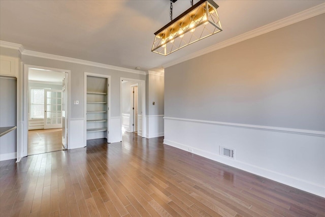 interior space with built in shelves, dark hardwood / wood-style floors, and crown molding