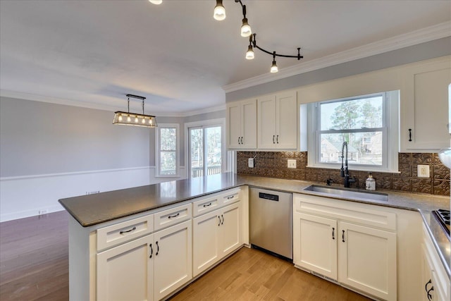 kitchen with stainless steel dishwasher, kitchen peninsula, sink, and white cabinets