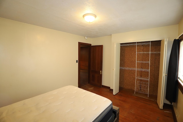 bedroom with dark hardwood / wood-style floors and a closet