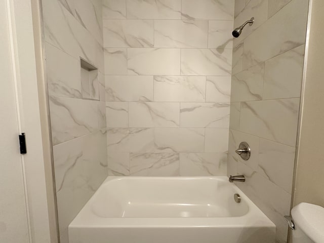 bathroom featuring shower / tub combination and toilet