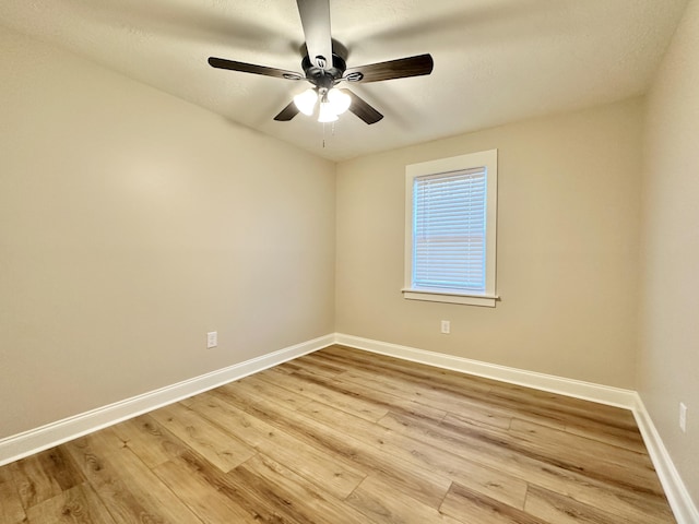 spare room with ceiling fan, baseboards, and wood finished floors