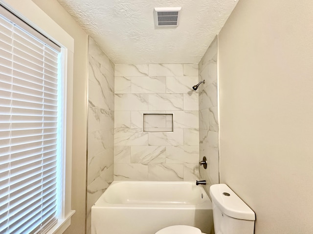 full bathroom featuring toilet, visible vents, shower / bathtub combination, and a textured ceiling