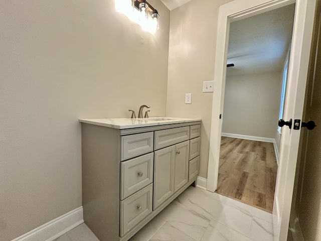 bathroom featuring marble finish floor, vanity, and baseboards