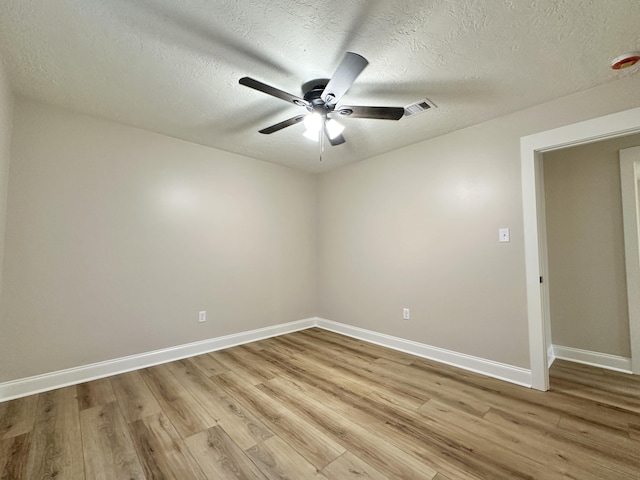 spare room featuring visible vents, baseboards, light wood-style floors, and a ceiling fan