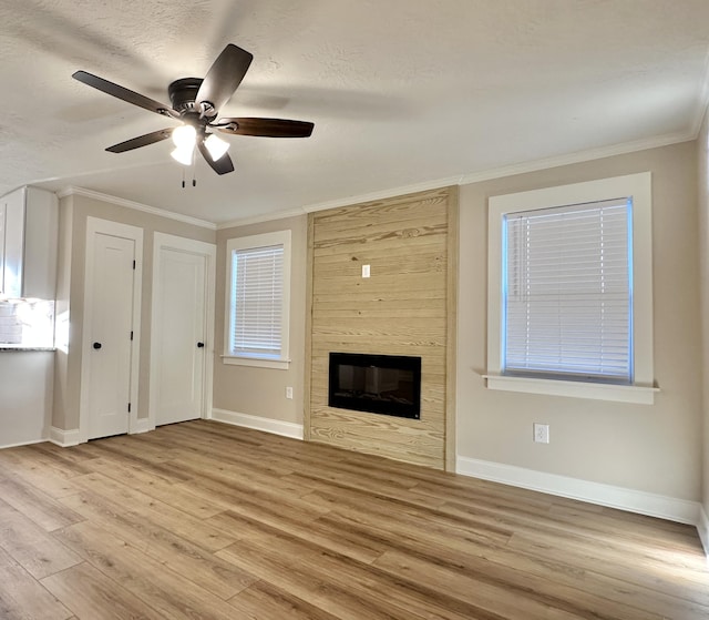 unfurnished living room featuring a fireplace, wood finished floors, a ceiling fan, and ornamental molding