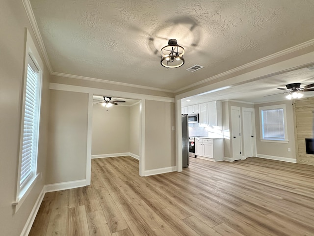 unfurnished living room featuring ceiling fan, visible vents, light wood-style floors, and a glass covered fireplace