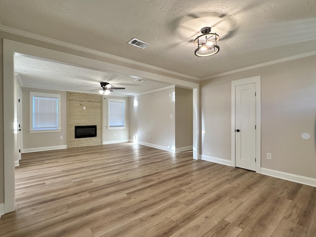 unfurnished living room featuring visible vents, ceiling fan, a textured ceiling, crown molding, and light wood-type flooring