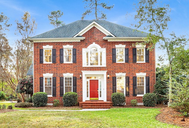 colonial-style house featuring a front lawn